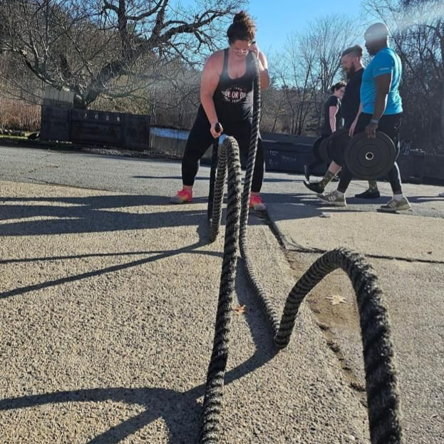 a group of people are doing sit ups in a gym .