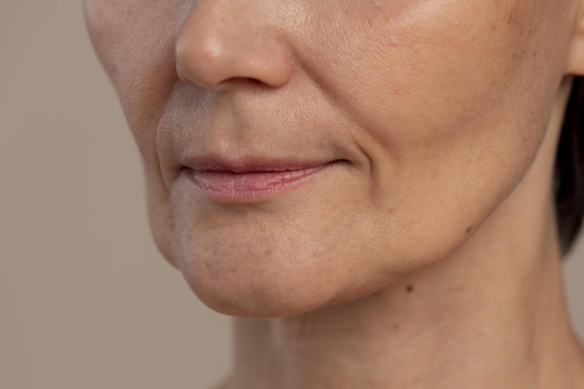 Un primer plano del rostro de una mujer con arrugas y una sonrisa.