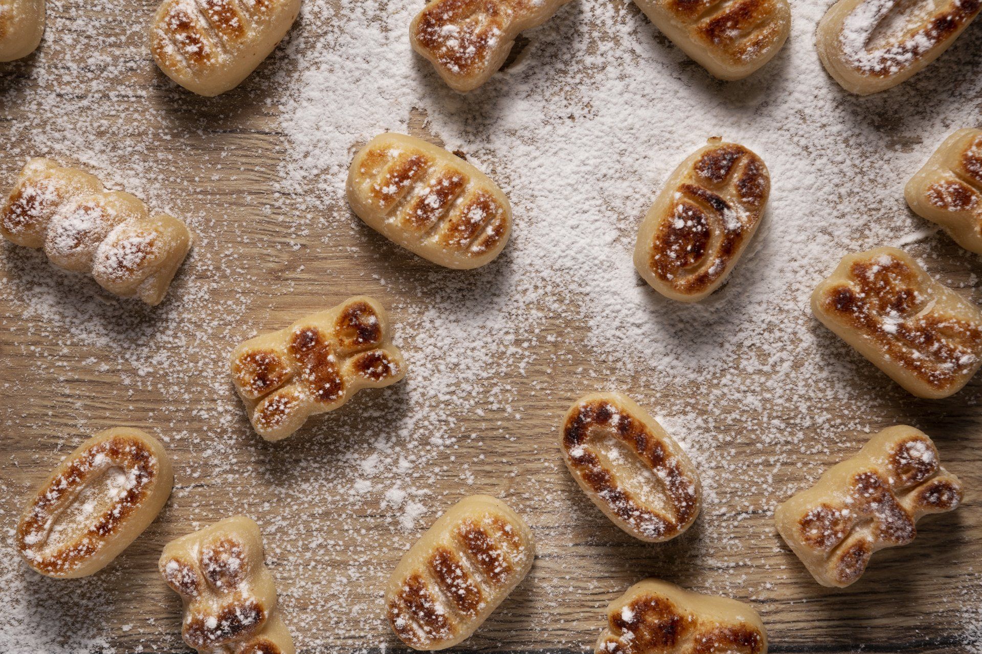 Un montón de galletas cubiertas de azúcar en polvo sobre una mesa de madera.