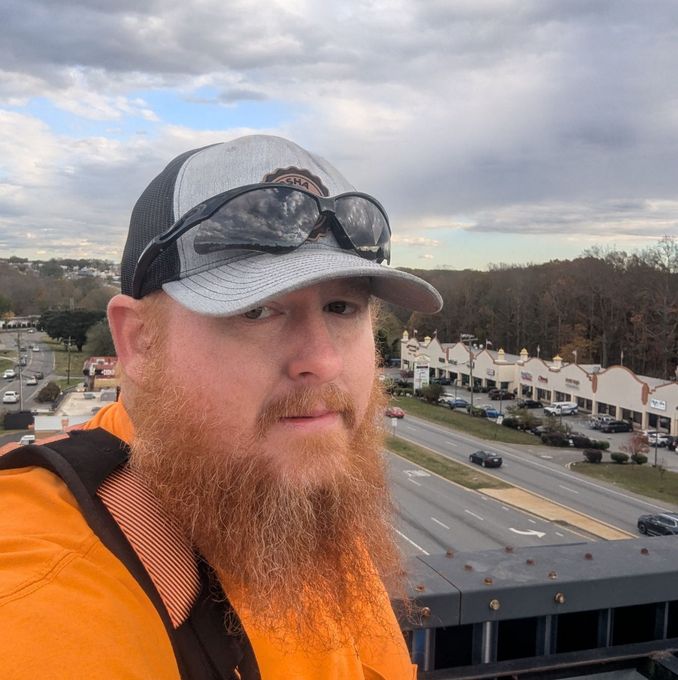 A man with a beard wearing a hat and sunglasses