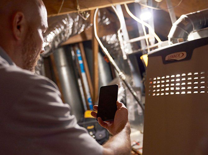 Man Holding A Phone — Bossier City, LA — Brooks Heating & Air Conditioning
