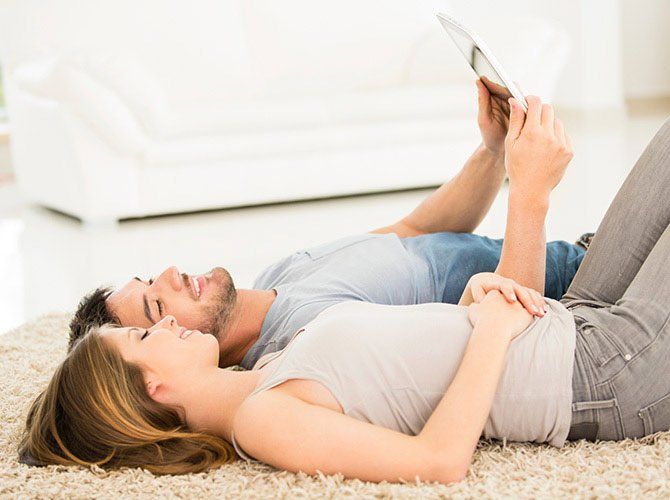 Couple Laying In The Living Room — Bossier City, LA — Brooks Heating & Air Conditioning