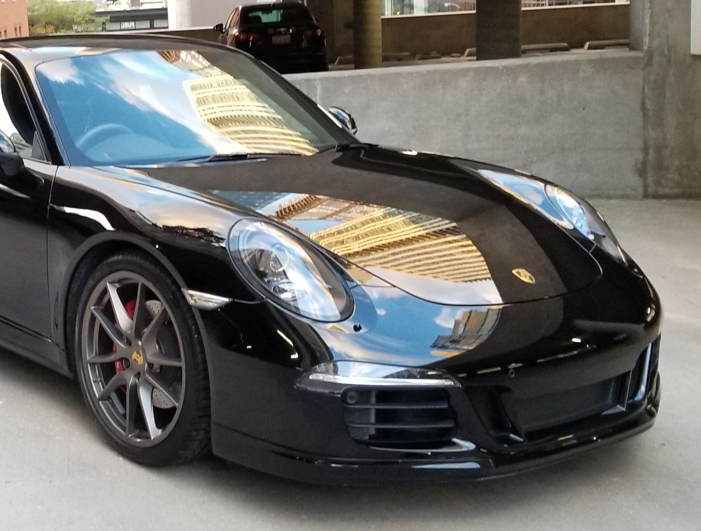 Black Porsche 911, parked with paint extremely glossy after a 2 step ceramic coating was applied.