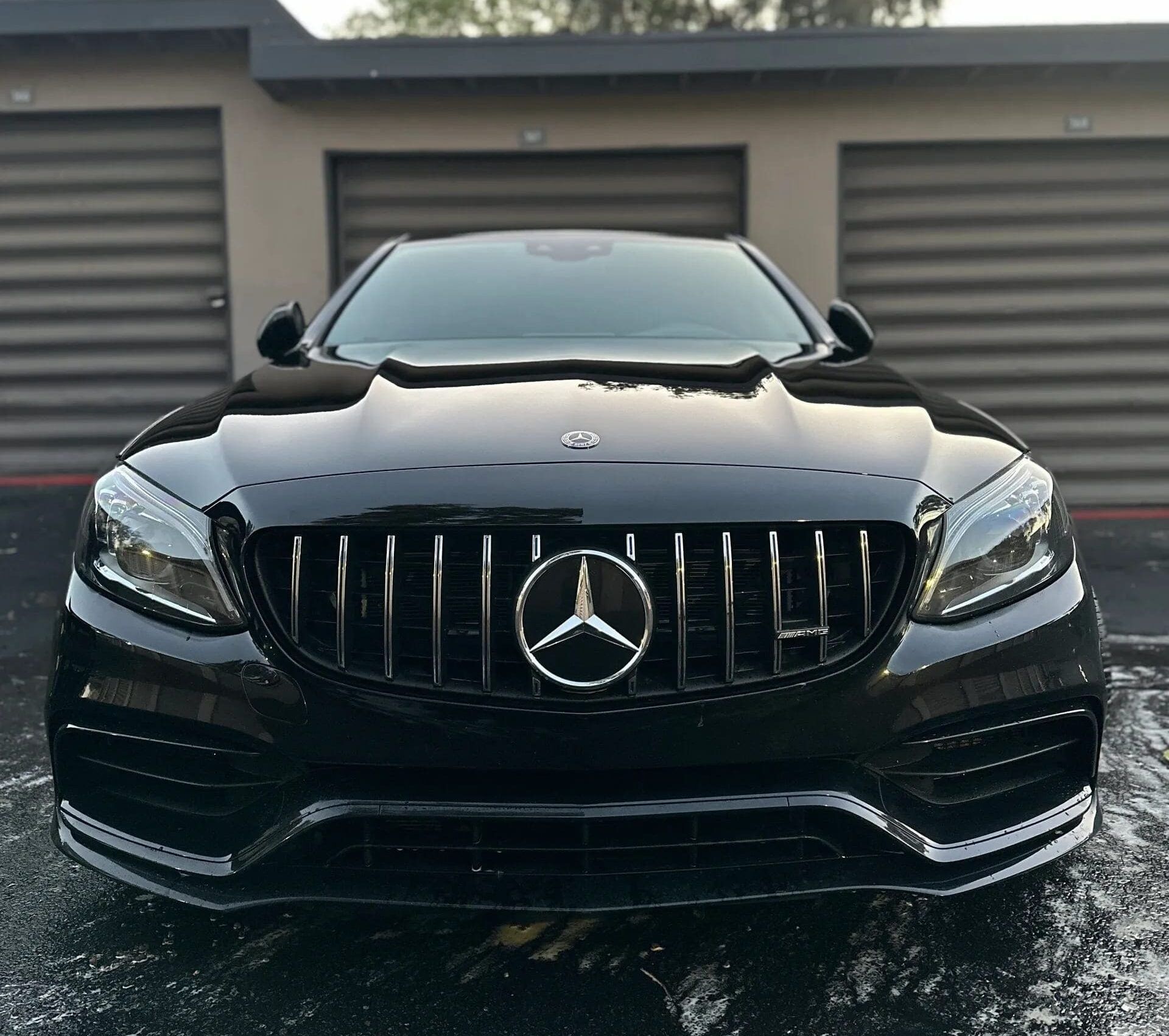 Black Mercedes-Benz AMG with a prominent grill, parked in front of a building after receiving the Masterclass Detail package.
