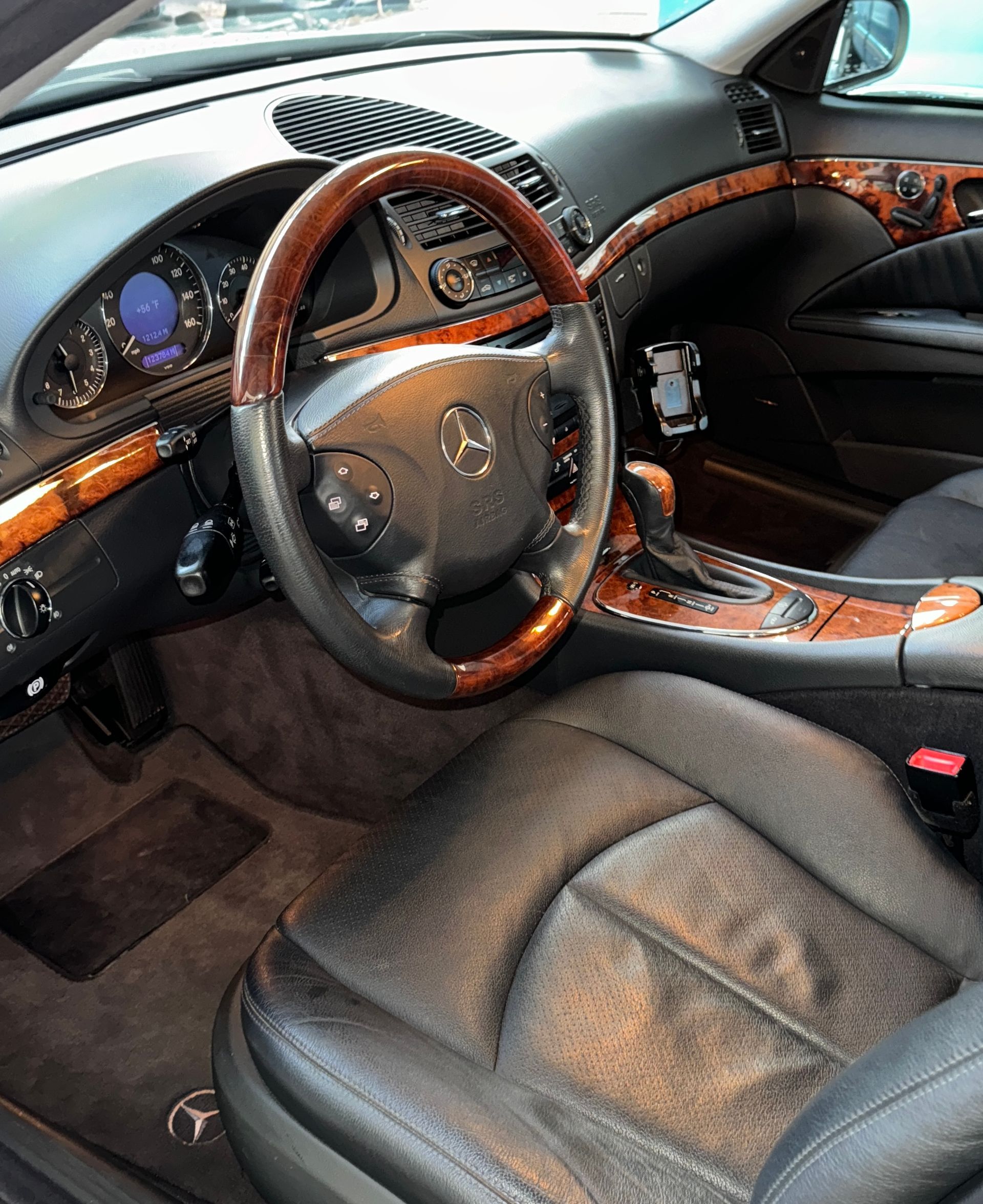 Finished Interior Detail of a Mercedes-Benz car, with black leather seats and wood trim.