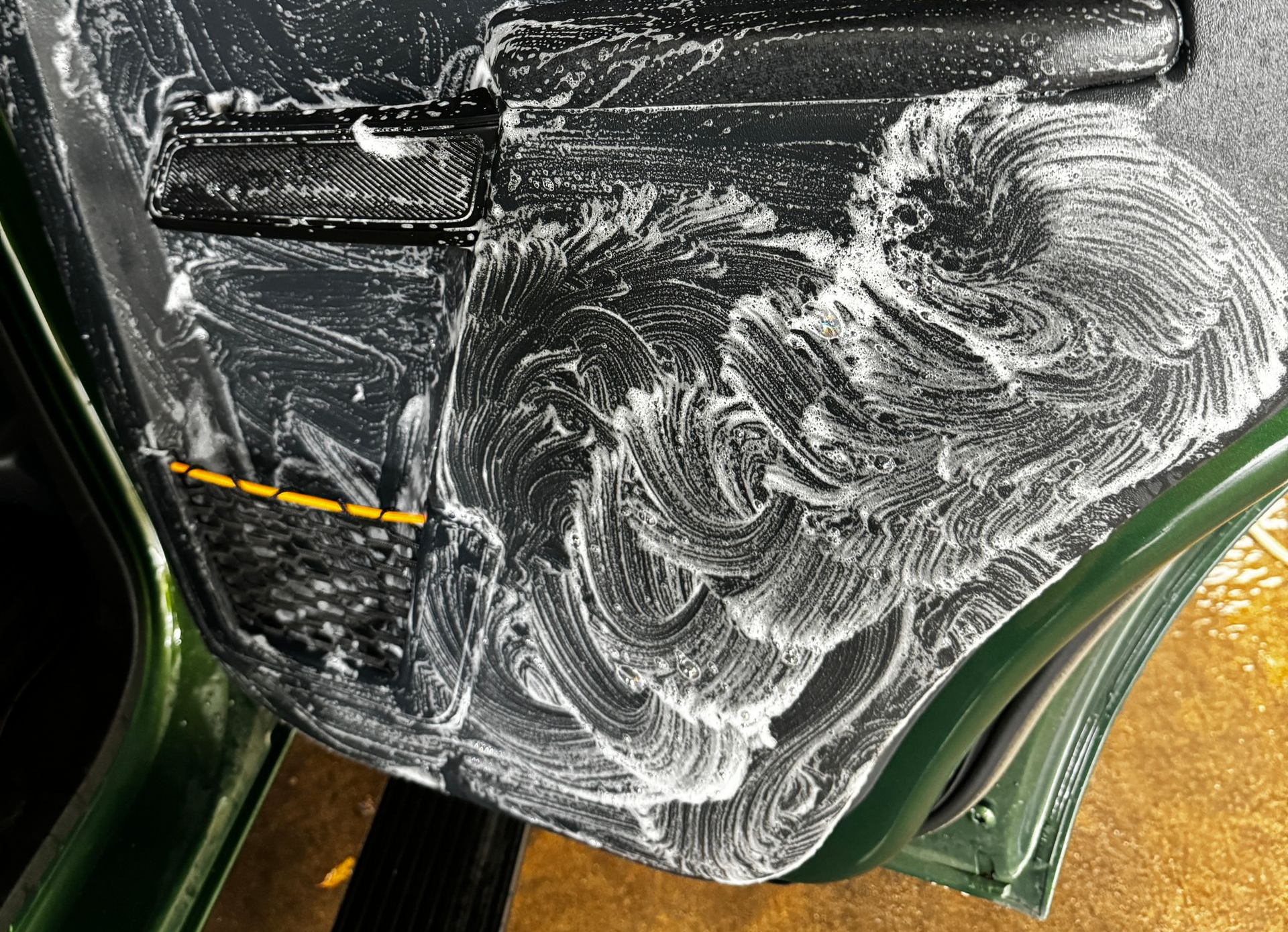Ford Bronco car door covered in white soapy foam from P&S Express cleaner making beautiful fluffy swirls.