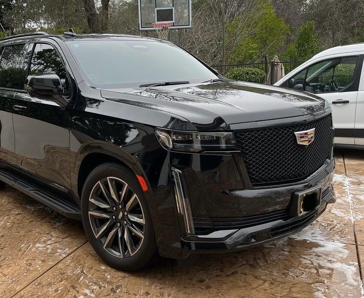 Black Cadillac Escalade SUV parked outside, after a full detail.