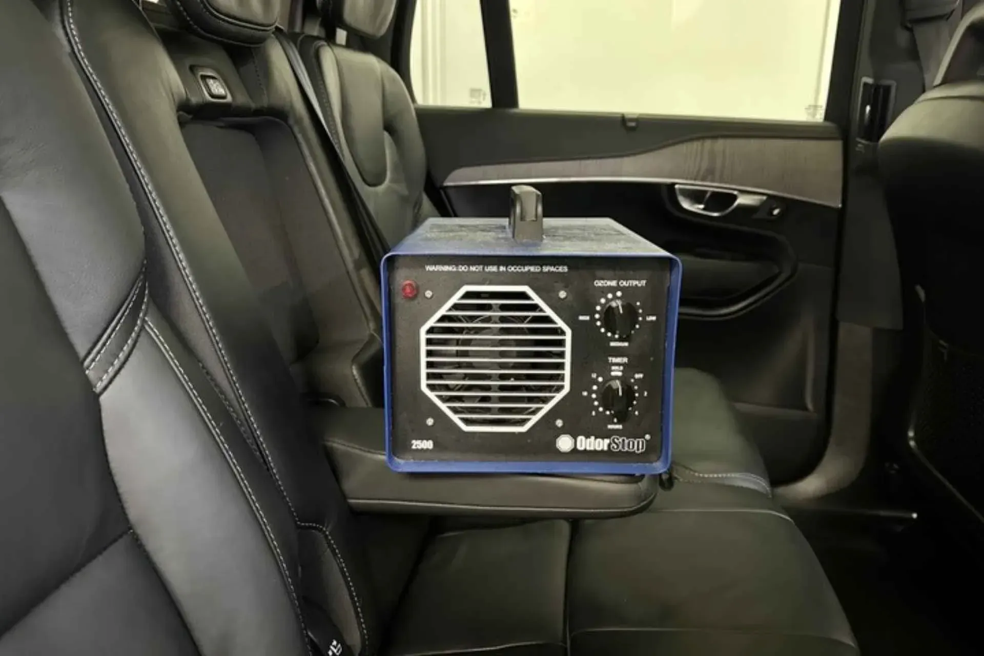 An ozone generator in a car, sitting on a back seat.