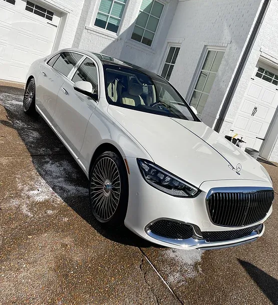 White Mercedes-Maybach sedan parked outside a white building after an express exterior detail.