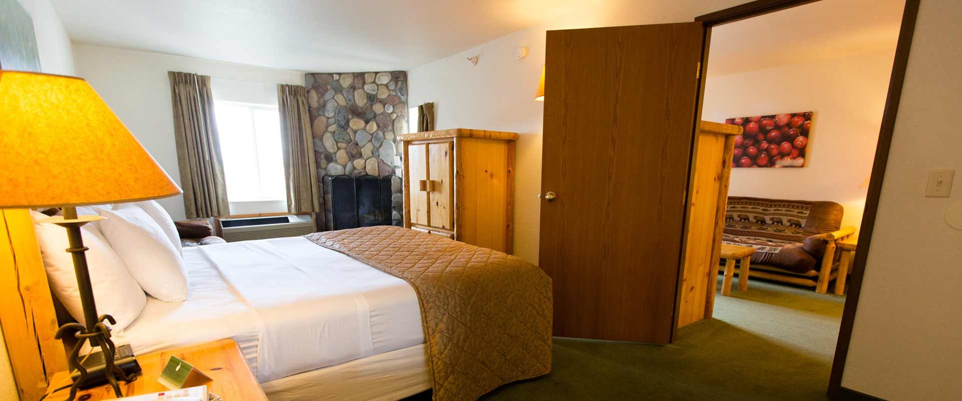 Bedroom with a king-sized bed, fireplace, and a doorway to a sitting area.