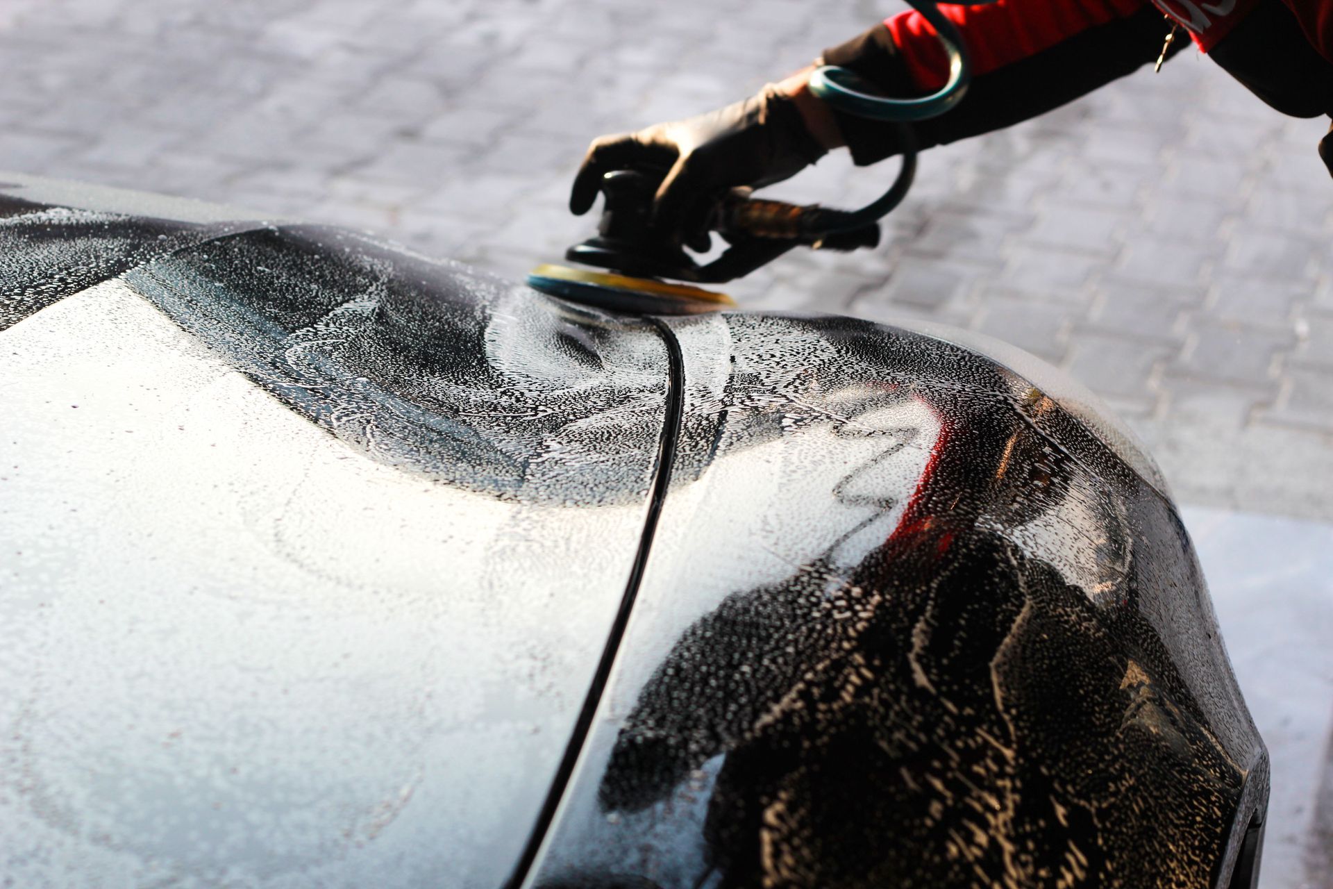 A man is using a machine to clean a sidewalk