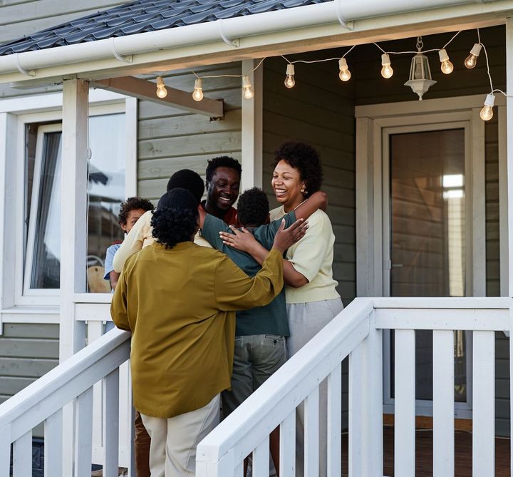 A group of people standing on a porch of a house