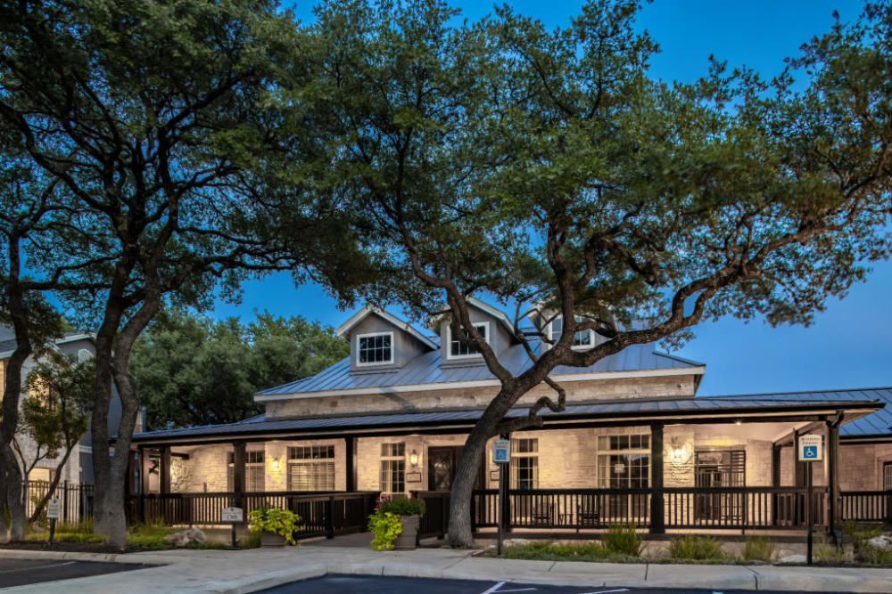 the clubhouse with a large porch and trees in front of it at Marquis at Deerfield in San Antonio, TX.