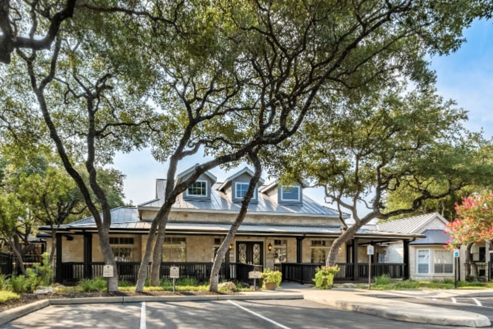 a clubhouse with a lot of trees in front of it at Marquis at Deerfield in San Antonio, TX.