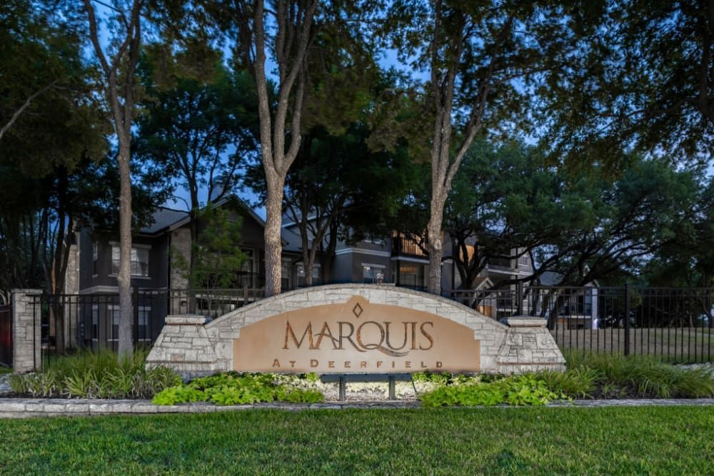 a sign for marquis is in front of a fence and trees at Marquis at Deerfield in San Antonio, TX.