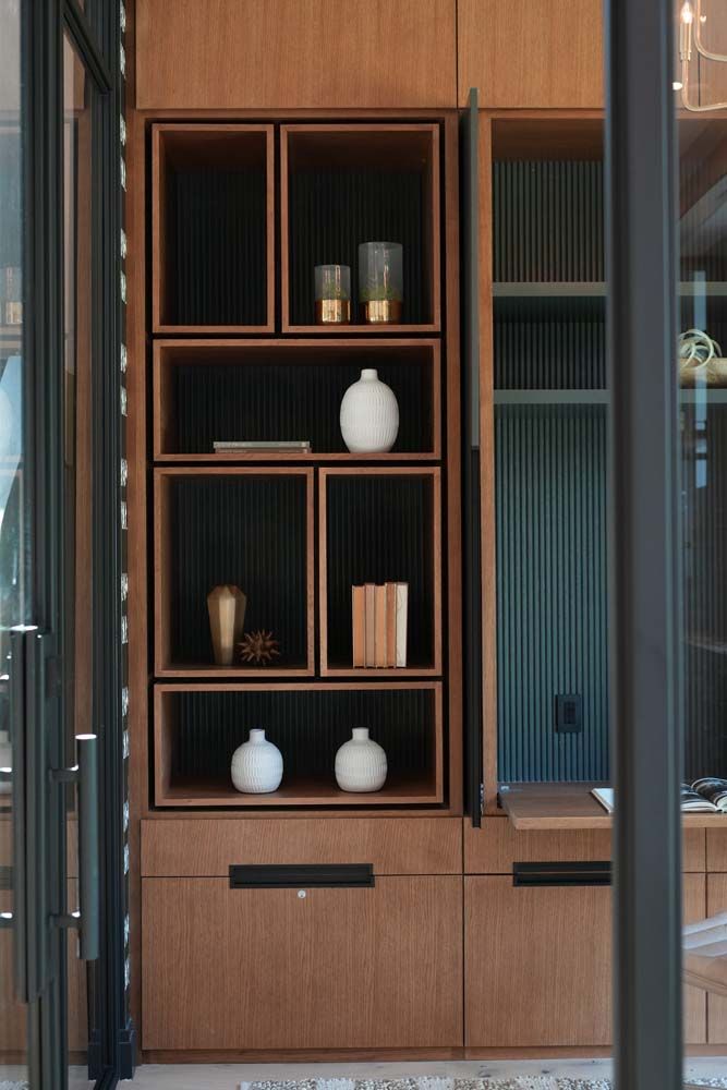 A wooden shelf with vases and books on it