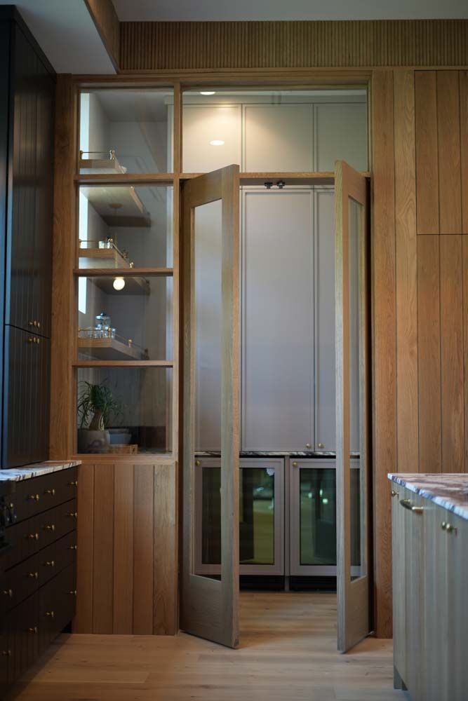 A kitchen with a glass door leading to a pantry.