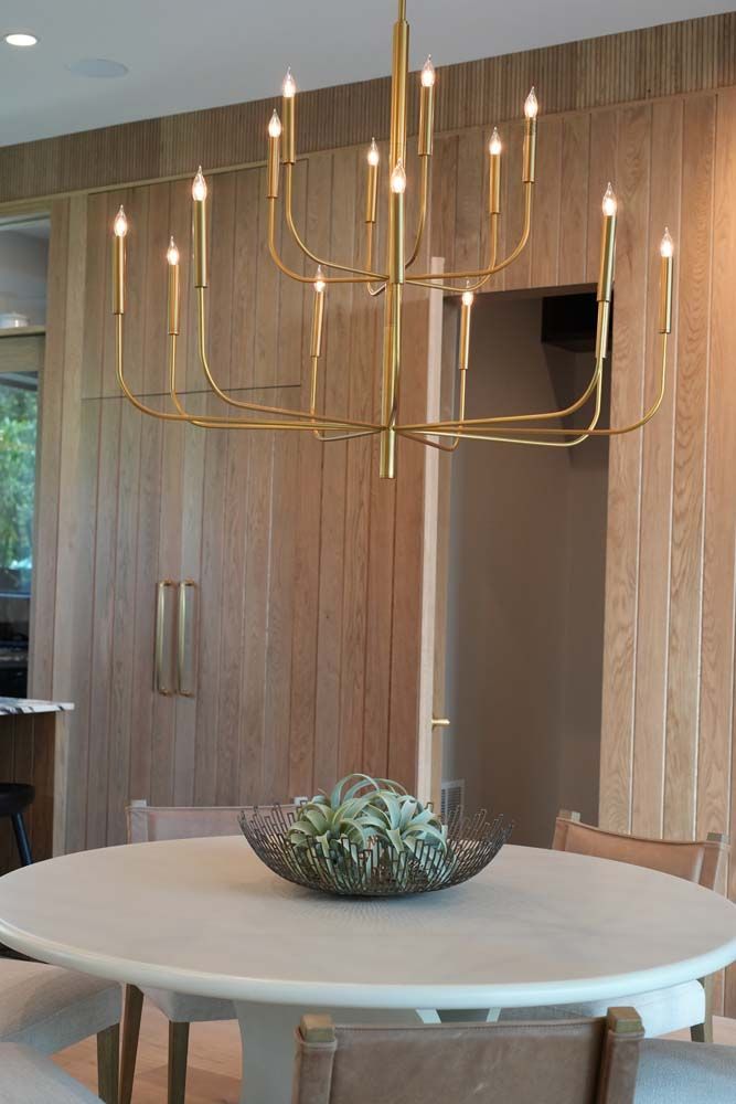 A dining room table with a chandelier hanging from the ceiling