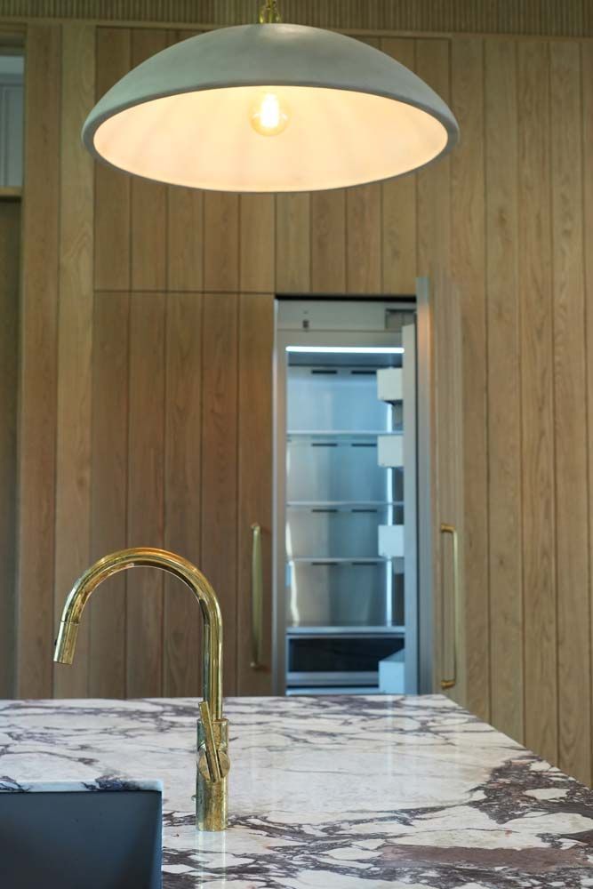 A kitchen with a sink , faucet , and refrigerator.