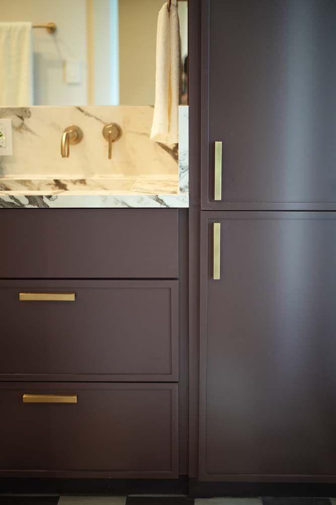 A bathroom with a sink , cabinets , drawers and a mirror.