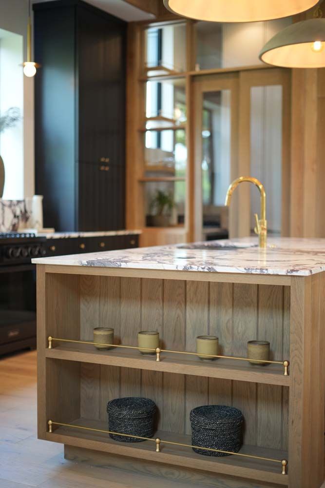 A kitchen with a wooden island and a marble counter top.
