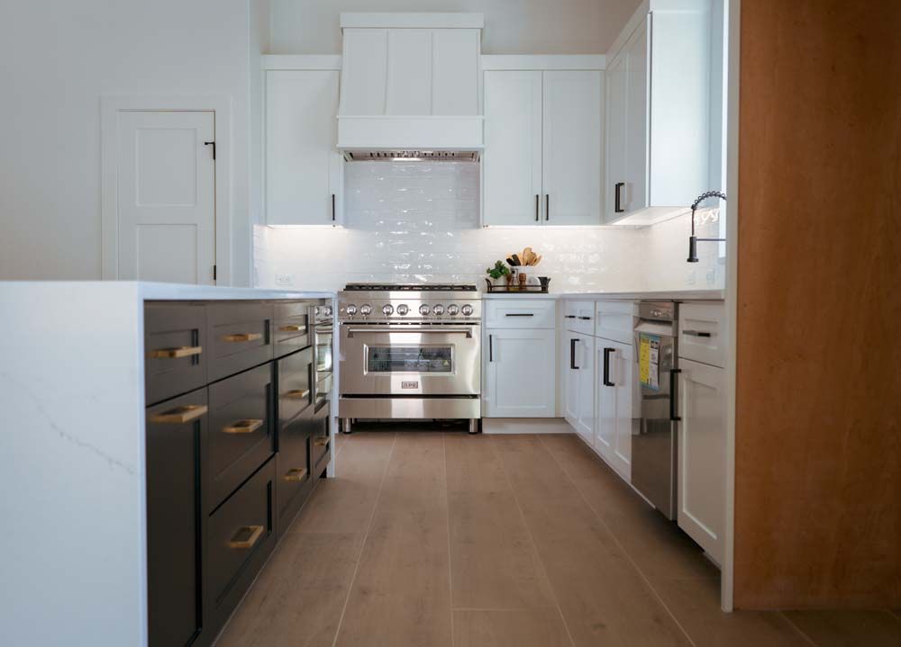 A kitchen with stainless steel appliances and white cabinets