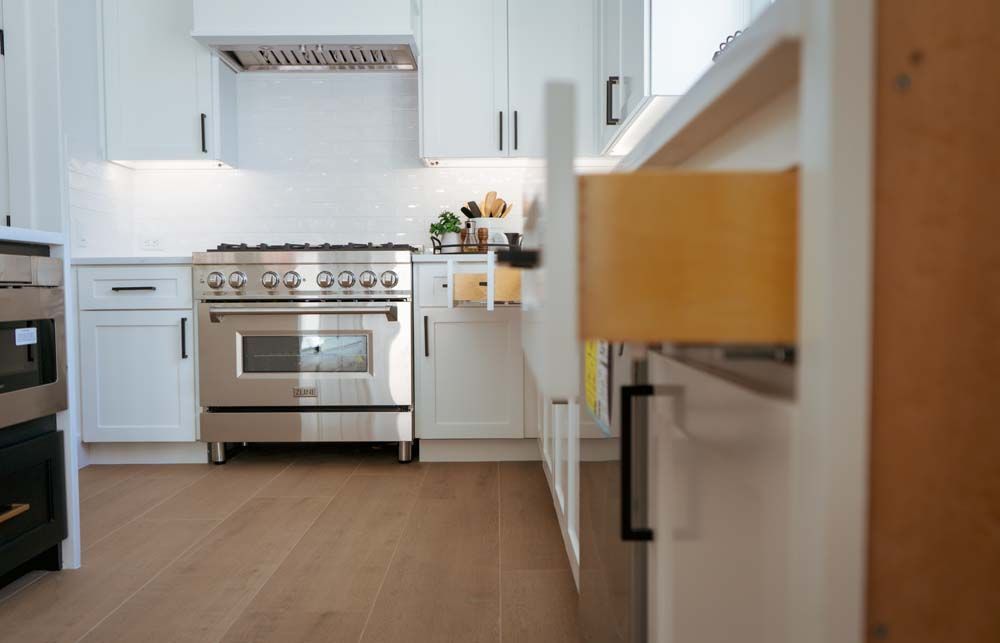 A kitchen with stainless steel appliances and white cabinets.
