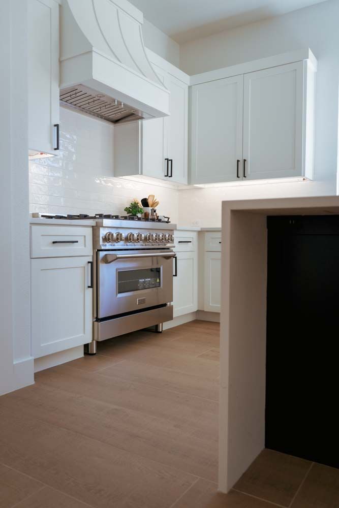 A kitchen with stainless steel appliances and white cabinets.