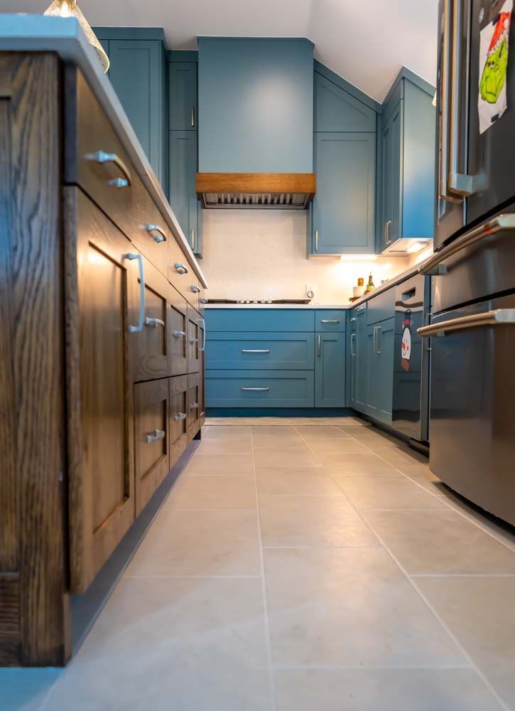 A kitchen with blue cabinets and stainless steel appliances.