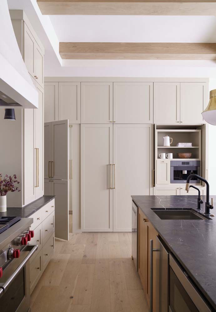 A kitchen with white cabinets and black counter tops