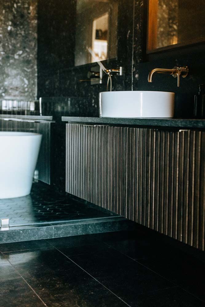 A bathroom with two sinks , a bathtub and a mirror.