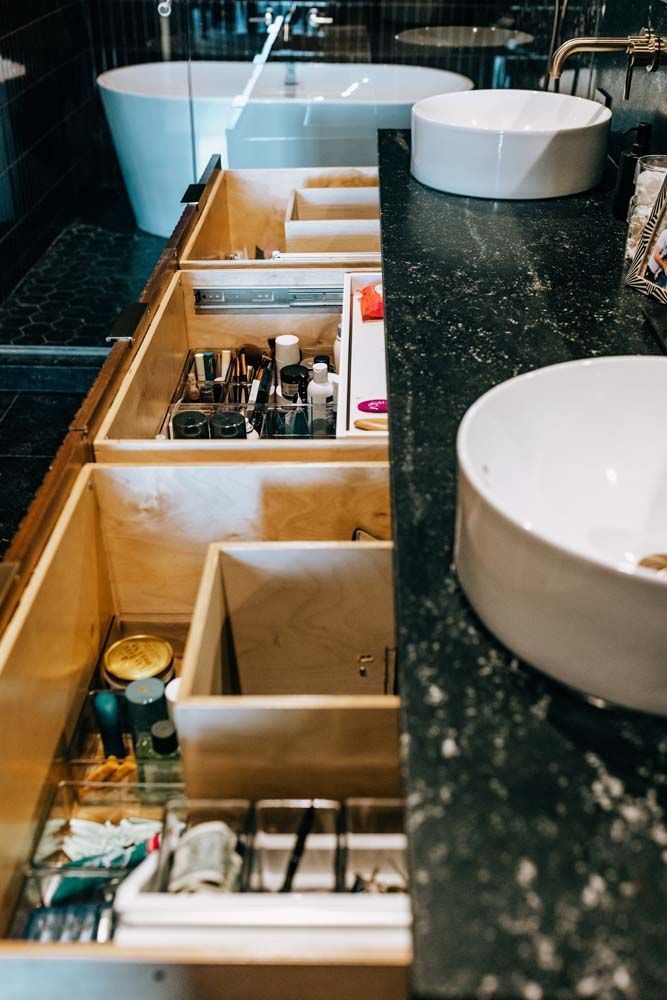 A bathroom with two sinks and lots of drawers.