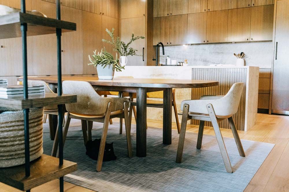 A dining room with a table and chairs in a kitchen.