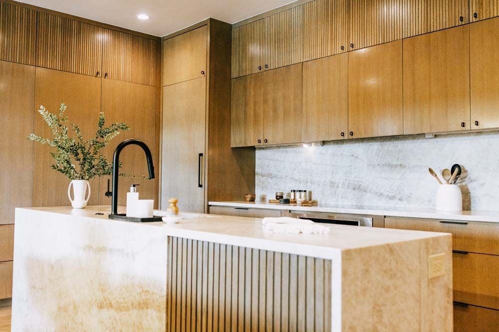 A kitchen with wooden cabinets and a large island.