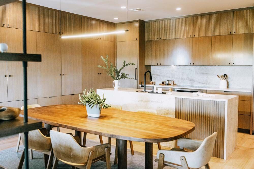 A kitchen with a wooden table and chairs in it.