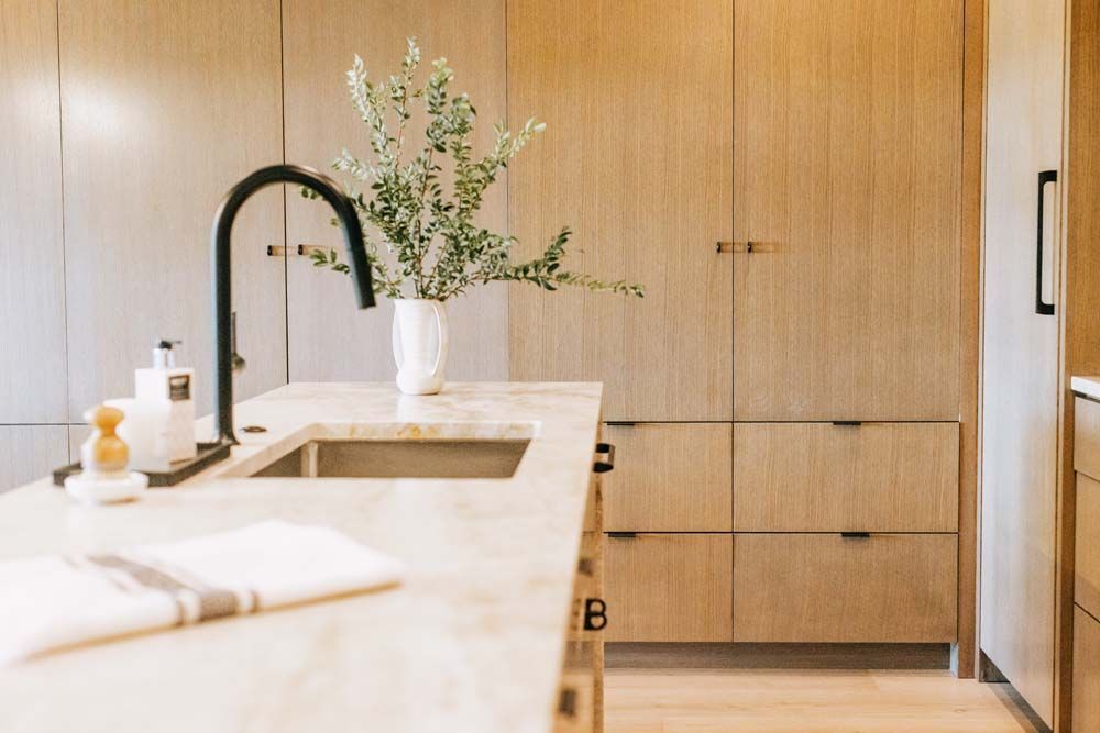 A kitchen with a sink , cabinets , drawers and a faucet.