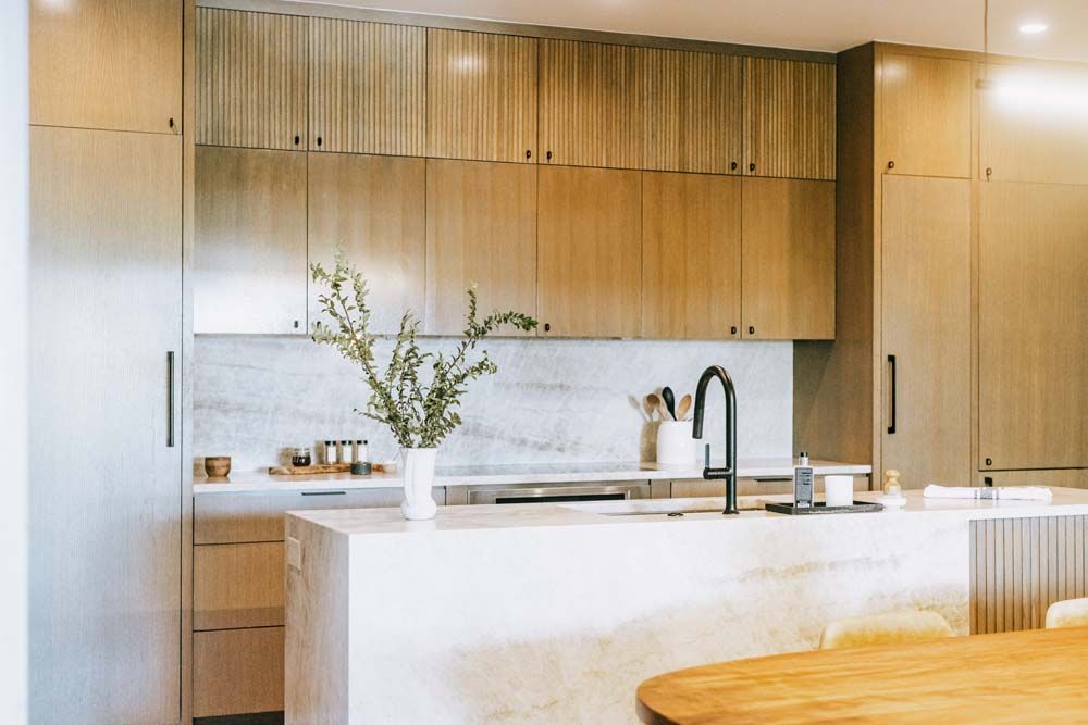 A kitchen with wooden cabinets and a white counter top.