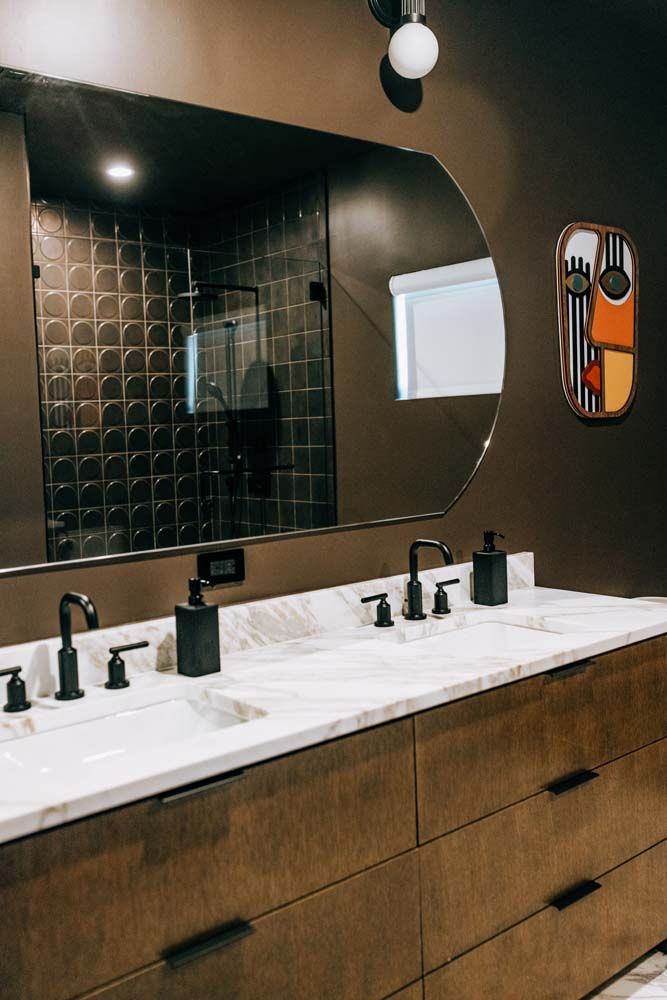 A bathroom with two sinks and a large mirror.