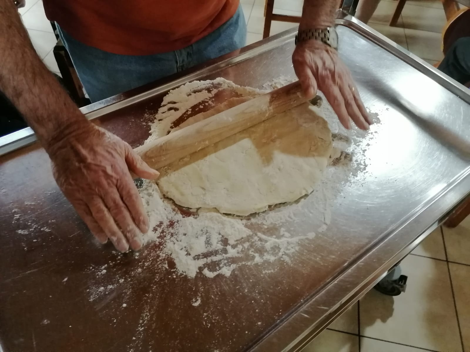 preparazione della pizza durante un'attività ricreativa della residenza per anziani