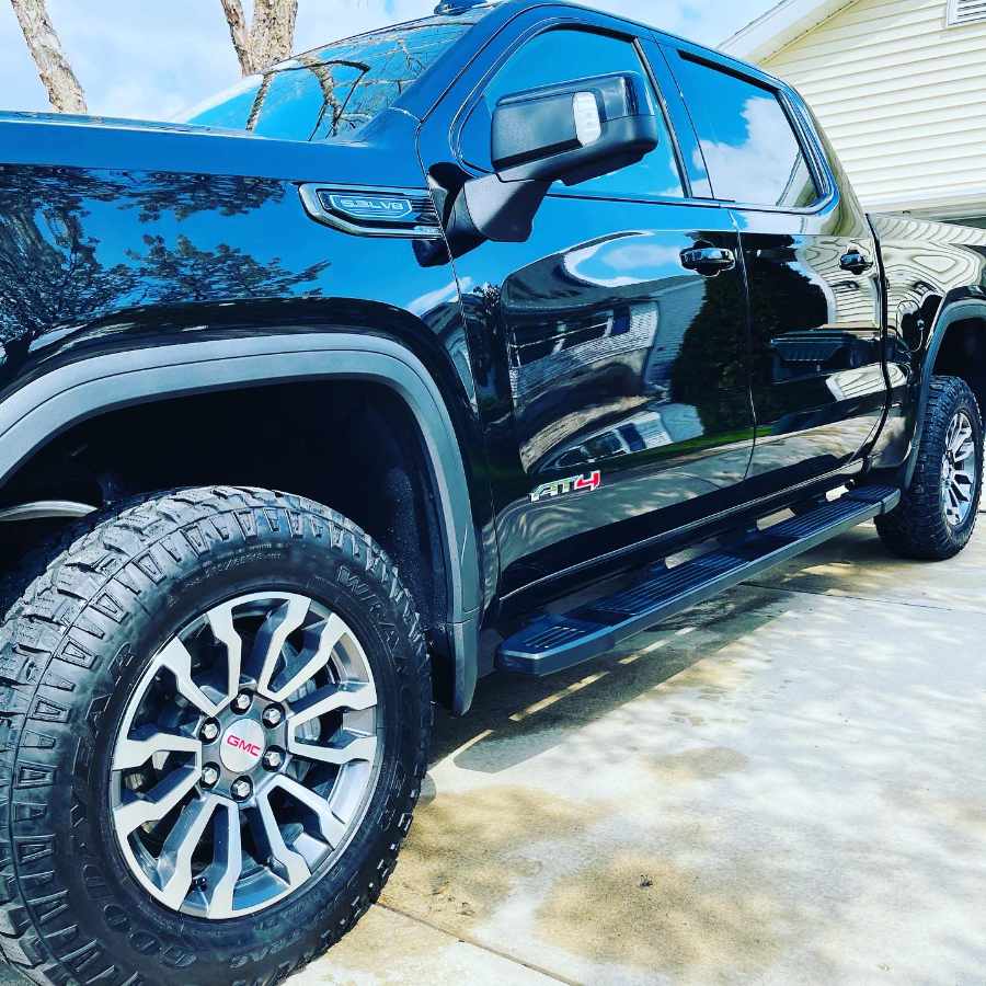 side of a glossy black gmc at4