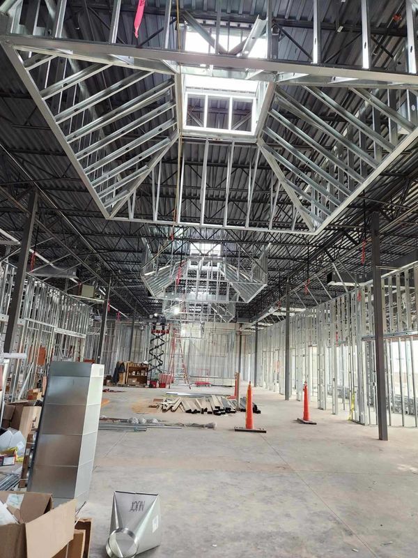 Interior of a building under construction with exposed metal framing and a skylight.