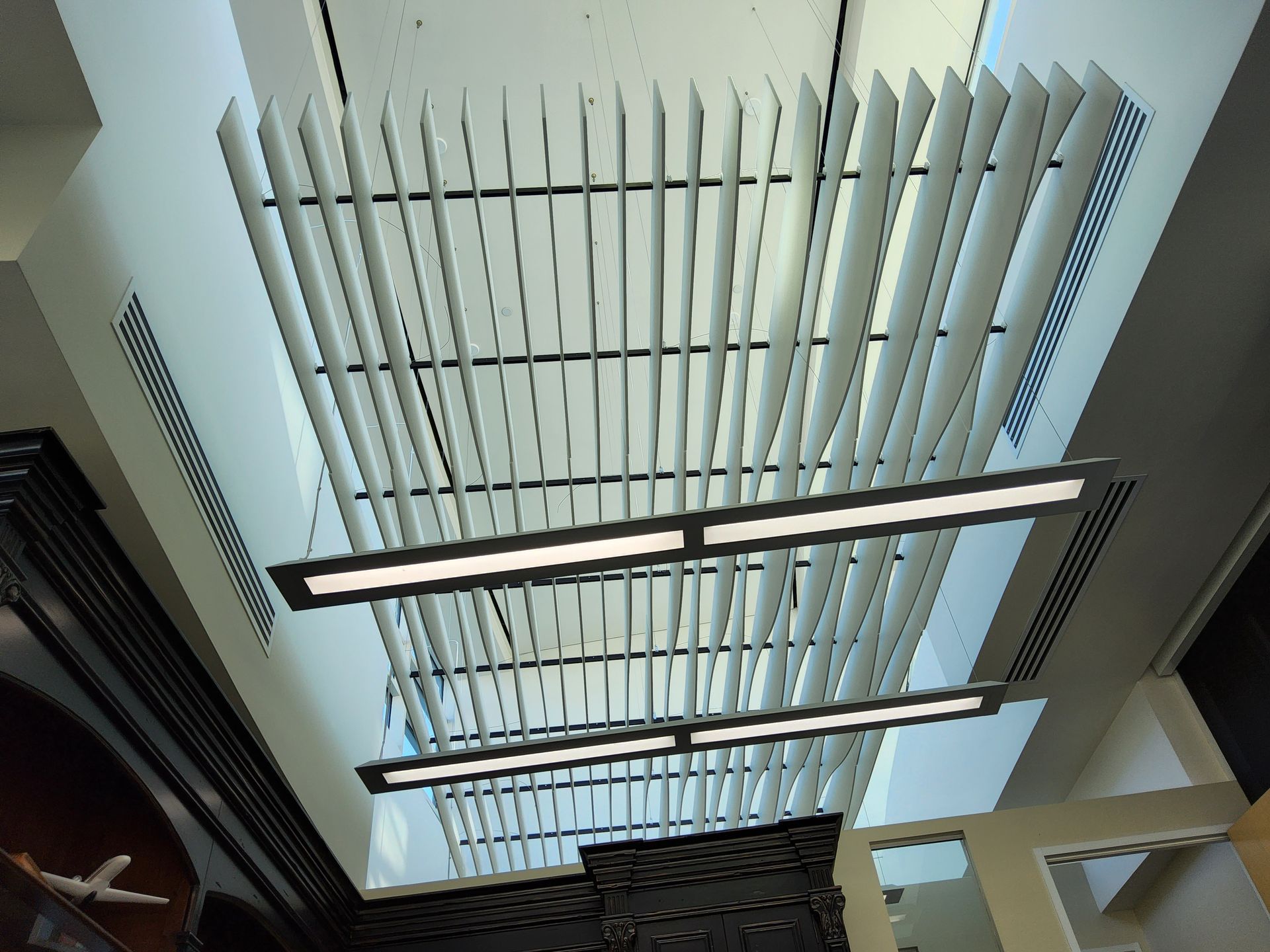 Modern ceiling with hanging light fixtures and white vertical slats.