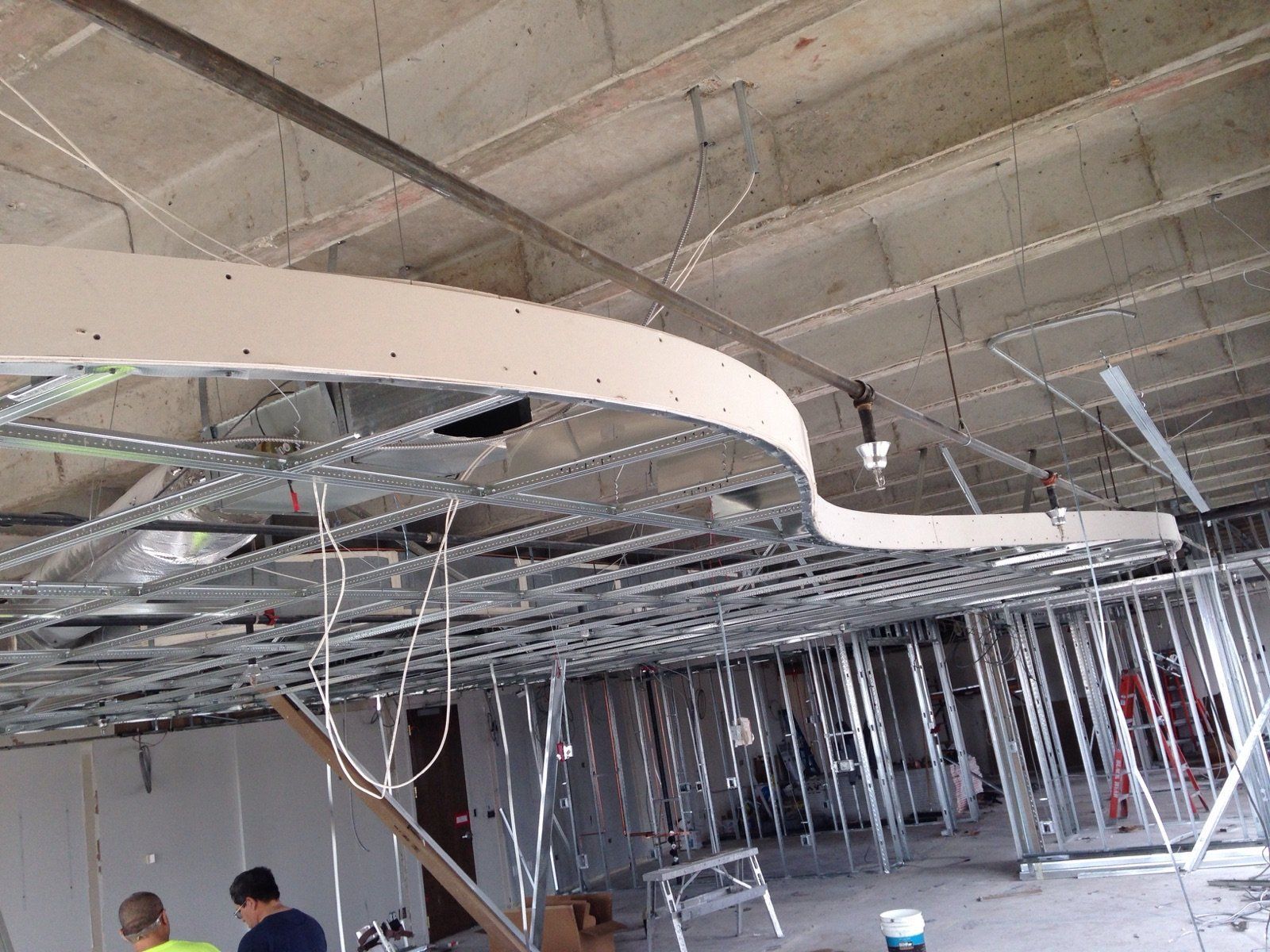 Construction site interior showing metal framing and curved drywall.