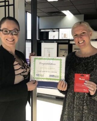 Two women standing next to each other holding a certificate that says congratulations