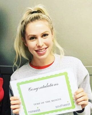 A woman is holding a certificate that says congratulations