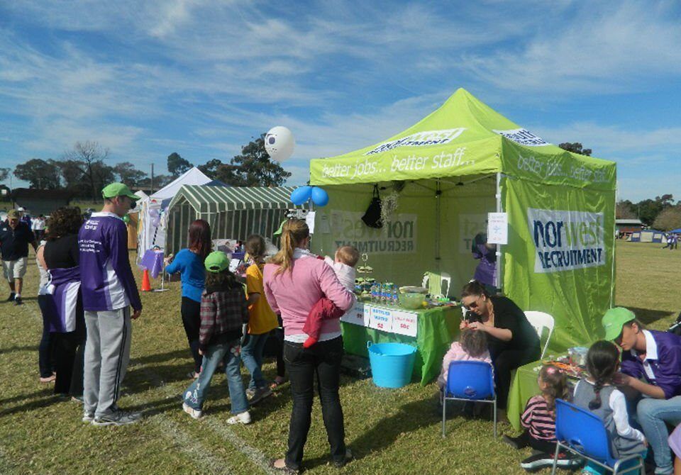 A group of people are gathered in front of a tent that says por was