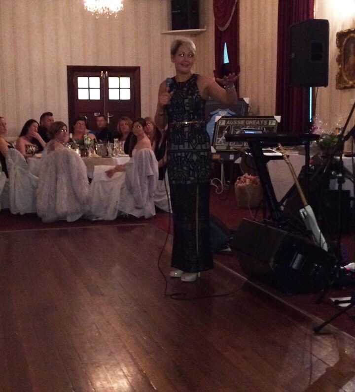 A woman singing into a microphone in front of a crowd