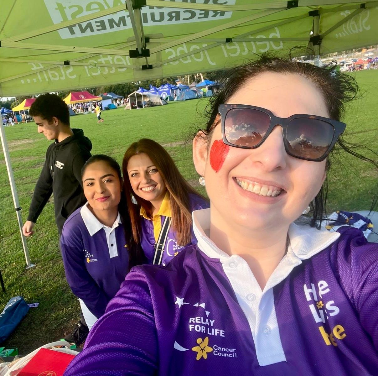 A group of people are standing in a room with their arms in the air.