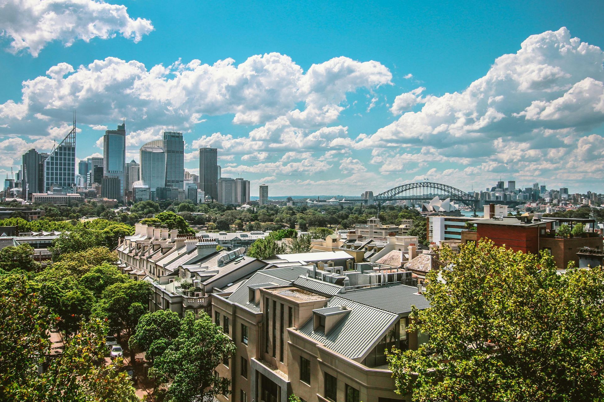 An aerial view of a city with buildings and trees in the foreground.