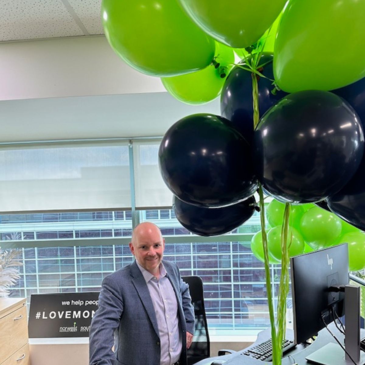 A man and a woman are standing next to a trophy.